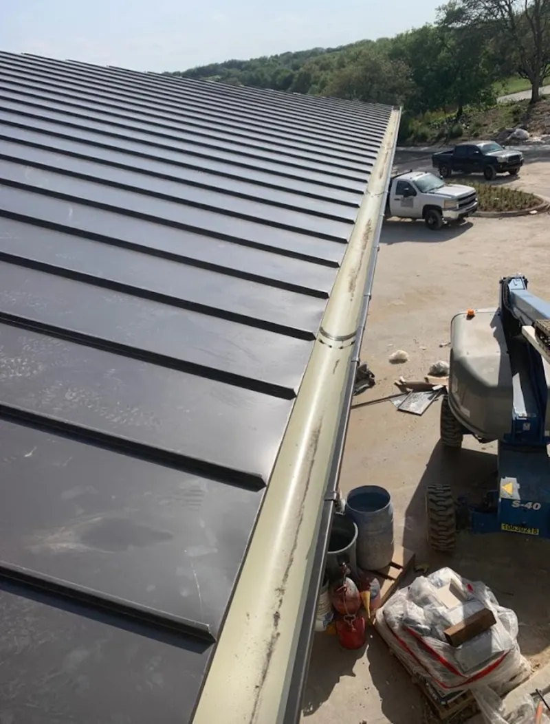 Standing seam panel and gutter detail on a metal roofing jobsite in Gulf Shores